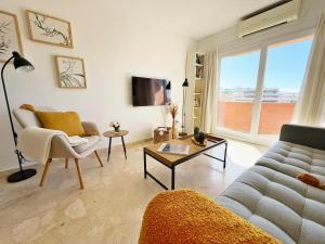 een woonkamer met een bank en een tafel bij Sunny & modern beach apartment in Fuengirola