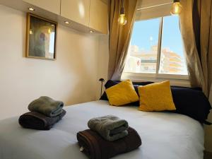 een slaapkamer met een bed met handdoeken en een raam bij Sunny & modern beach apartment in Fuengirola