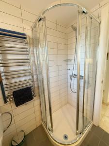 een douche met een glazen deur in een badkamer bij Sunny & modern beach apartment in Fuengirola