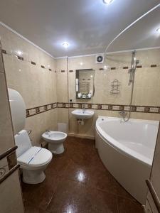 a bathroom with a tub and a toilet and a sink at Hotel&Restaurant SENATOR in Truskavets +56 photos