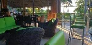un restaurante con mesas y sillas verdes y negras en COCOON Koh Chang, en Ko Chang