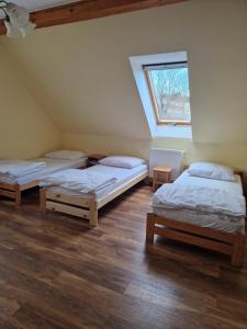 a room with three beds and a window at Schronisko Sokoliki in Mysłakowice