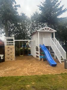 a playground with a slide and a play house at Apartamet Gabriel in Tykocin