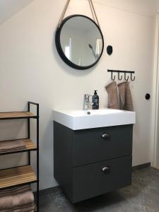 a bathroom with a sink and a mirror on the wall at Sjönära boende längs Skåneleden in Sövde +3 photos