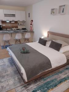 a bedroom with a large bed and a kitchen at Repi-Tár apartman in Szolnok