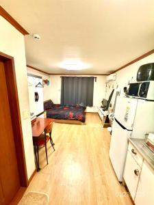 a kitchen and living room with a refrigerator and a table at Spacious Studio Apt (Myeong-dong) in Seoul +3 photos