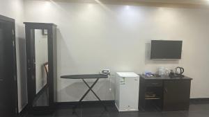 a room with a small table and a small refrigerator at فندق ياسر الضلعي لى ريلاكس الفندقية-YASER ALDHILAY LE RELAX HoTEL in Buqayq