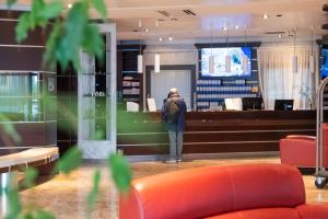 a person is standing in a store lobby at Dado Hotel International in Parma