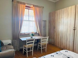 Una habitación con una mesa y sillas y una ventana. en Great choice, en Ciudad del Cabo