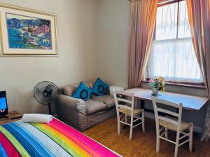 una habitación con una cama, una mesa y un sofá en Great choice, en Ciudad del Cabo
