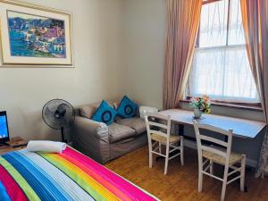 una habitación con una cama, una mesa y un sofá en Great choice, en Ciudad del Cabo
