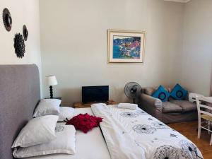 Un dormitorio con una cama grande y un sofá. en Great choice, en Ciudad del Cabo
