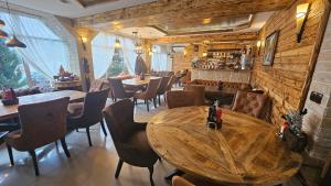 a restaurant with wooden tables and chairs and a bar at Апартамент Bella Casa in Beli Iskar