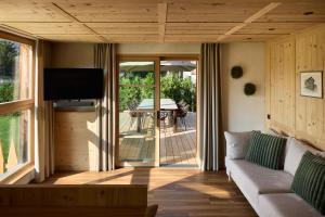 a living room with a couch and a view of a patio at Chalet La Varieté in La Villa