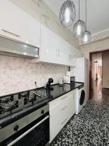 een keuken met witte kasten en een zwart aanrechtblad bij Charment appartement a vinaros in Vinarós