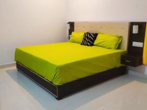 a bedroom with a bed with yellow sheets and pillows at Entire apartment khajuraho in Khajurāho