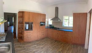 a large kitchen with wooden cabinets and a sink at Gelwal self catering house in Thornhill