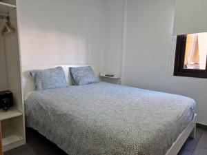 una camera da letto con un letto con due cuscini blu di Chitamar ad Arona