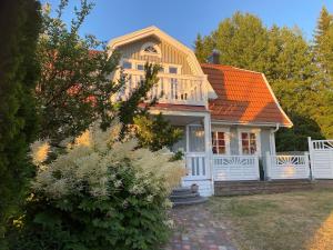 a white house with an orange roof at Grand 5 Room Villa in Kallfors, Järna, Stockholm near Forest, the Baltic Sea and a Golf course - a whole house no shared rooms in Järna
