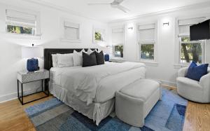 a white bedroom with a large bed and a chair at Just for Fun 2 in Santa Rosa Beach +39 photos