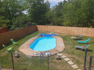 een zwembad in een tuin met stoelen en een hek bij Maison familiale avec piscine in Gurgy