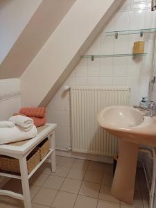 bagno bianco con lavandino e lavandino di La maison de Claire a Saint-Servant