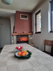 a plate of fruit on a table with a fireplace at Andreevite Houses in Sapareva Banya