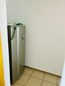 a small silver refrigerator in a corner of a room at Departamento zona industrial in San Luis Potosí