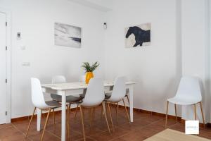 a white dining room with a white table and white chairs at Guayantovel Doñana in Villamanrique de la Condesa