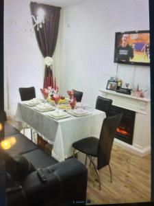 Una sala de estar con mesa y sillas y una chimenea. en Lux studio 46 meters, en Colentina