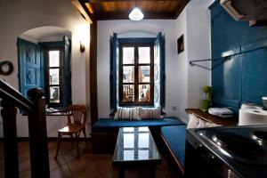 a living room with a blue couch and a table at Kantouni Bay Suites in Kalymnos