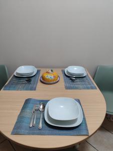 a wooden table with plates and utensils on it at Diana's home in Empoli +2 photos