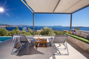 un patio avec deux chaises, une table et un canapé dans l'établissement Brand new High-end villa Astro, à Sývota