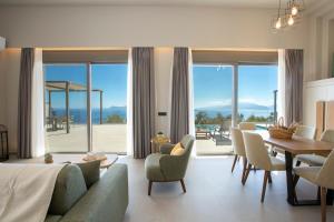 un salon avec un lit, une table et des chaises dans l'établissement Brand new High-end villa Astro, à Sývota