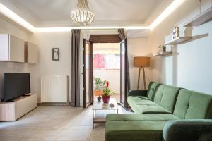a living room with a green couch and a television at Archanes Philoxeno Appartment in the Village in Archanes