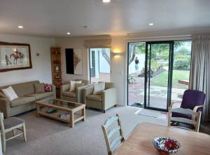 MapuaにあるDoonside Private Cottage at Grossi Point Reserveのソファとテーブルのあるリビングルーム