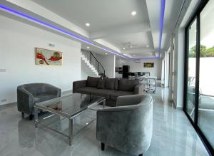 een woonkamer met een bank, stoelen en een tafel bij PATTAYA POOL VILLA 427 nearby WALKING STREET in Pattaya South +38 foto's