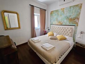 Un dormitorio con una cama con un cuadro en la pared. en Cellini apartments, en Roma