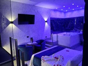 a purple room with a bed and a bath tub at Hotel Joy in Castel Volturno