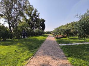 a brick path in a park with trees and grass at Seiterre Agriturismo Tenuta San Leone in Valeggio sul Mincio