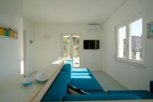 a living room with blue couches and a television at Borgo Antico - Casa White Tellaro P1 in Tellaro