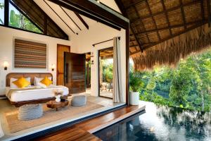 a bedroom in a villa with a bed and a pool at Kalani River Villas in General Luna