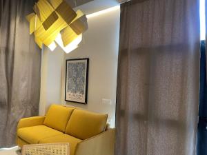 un soggiorno con divano giallo e finestra di Osito Hub - Campoamor a Valencia