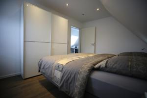 a bedroom with a bed and a large window at Eine sehr gemütliche Dachgeschoß Ferienwohnung in Ihlow +30 photos