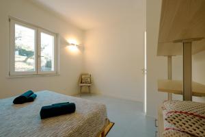 a bedroom with a bed and a window at Borgo Antico - Casa White Tellaro P1 in Tellaro