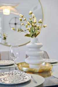 un vase blanc avec des fleurs sur une table dans l'établissement Azure Carmel Apartment Flamenca Village, à Orihuela Costa 62 autres photos