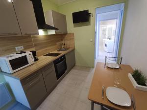 une cuisine avec un four micro-ondes sur un comptoir et une table dans l'établissement Appartement tout equipé à 600m du centre thermal, à Lamalou-les-Bains 3 autres photos