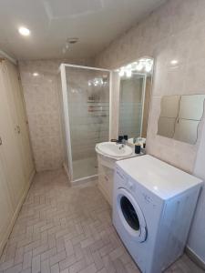 une salle de bains avec lave-linge et lavabo dans l'établissement Appartement tout equipé à 600m du centre thermal, à Lamalou-les-Bains
