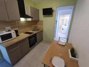 - une cuisine avec une table et un four micro-ondes dans l'établissement Appartement tout equipé à 600m du centre thermal, à Lamalou-les-Bains