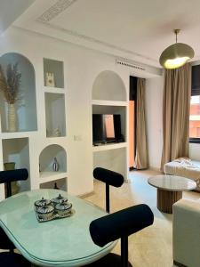 a living room with a table and some chairs at Cosy appartement au cœur de Gueliz in Marrakech
